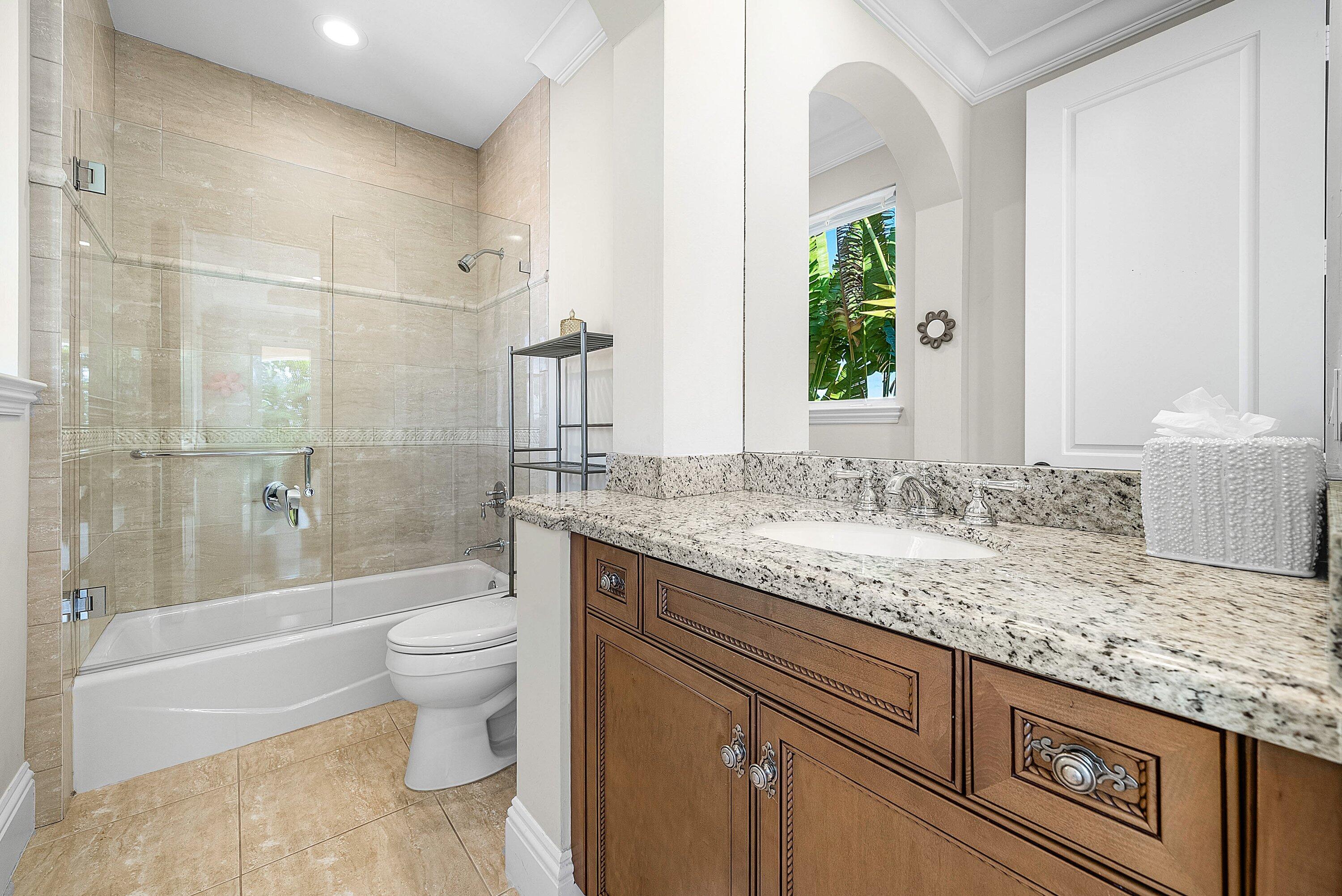 398 Northeast 7th Street Boca Raton, FL 33432 - Photo 47 of 74 a bathroom with a granite countertop sink a toilet and shower