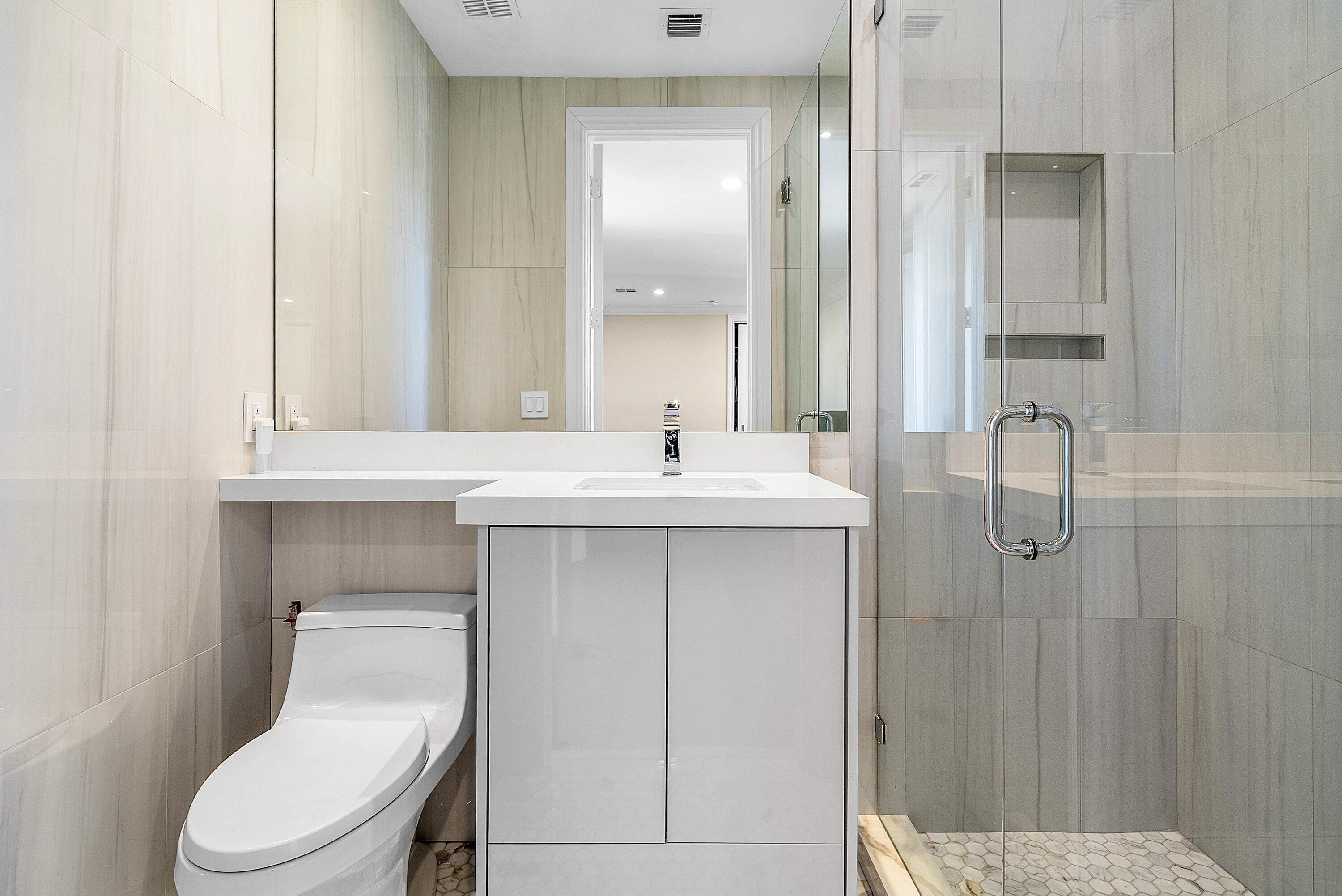 398 Northeast 7th Street Boca Raton, FL 33432 - Photo 48 of 74 a bathroom with a toilet sink and mirror