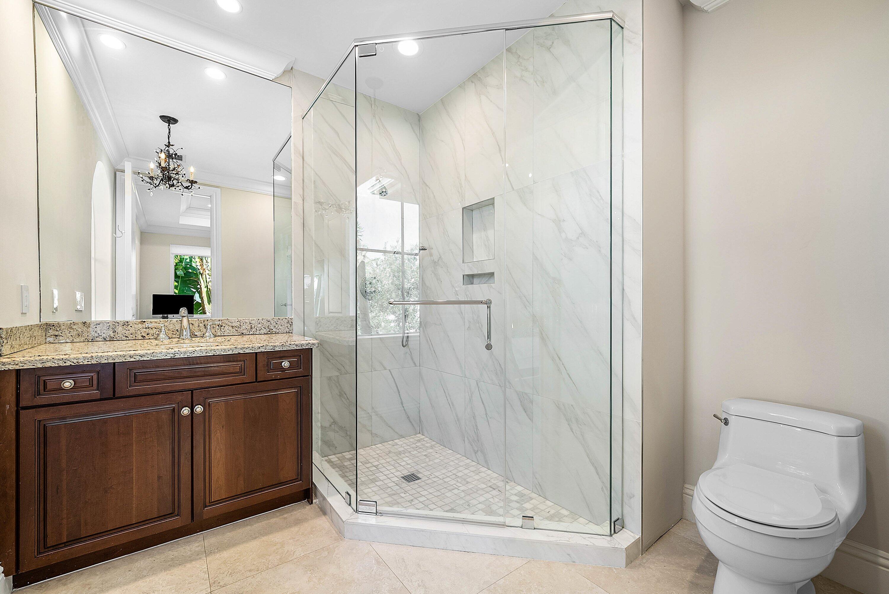 398 Northeast 7th Street Boca Raton, FL 33432 - Photo 52 of 74 a bathroom with a granite countertop sink a toilet and shower