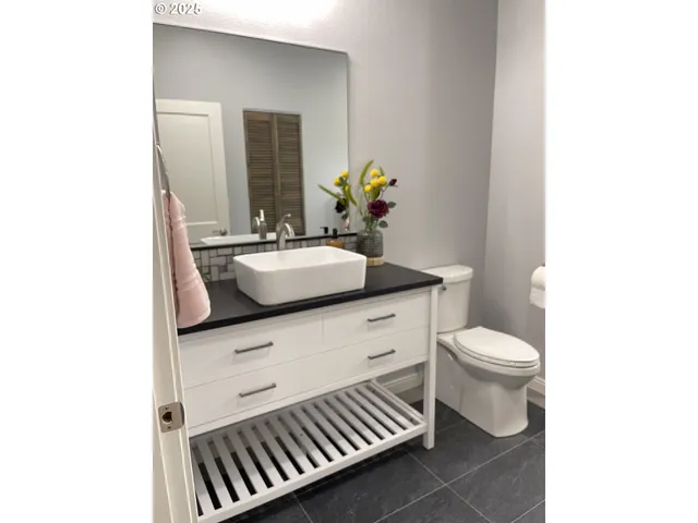 a bathroom with a sink a toilet and mirror