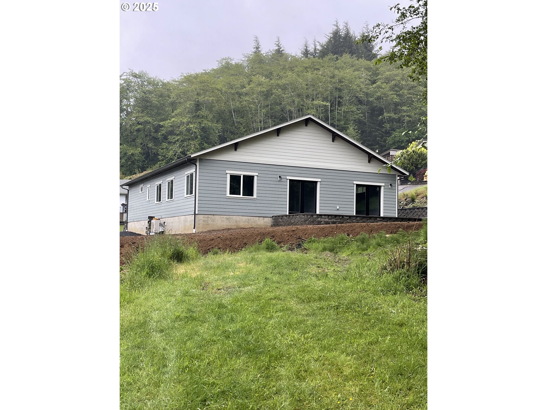 905 Bellevue Drive Reedsport, OR 97467 - Photo 34 of 37 a backyard of a house with large trees and plants