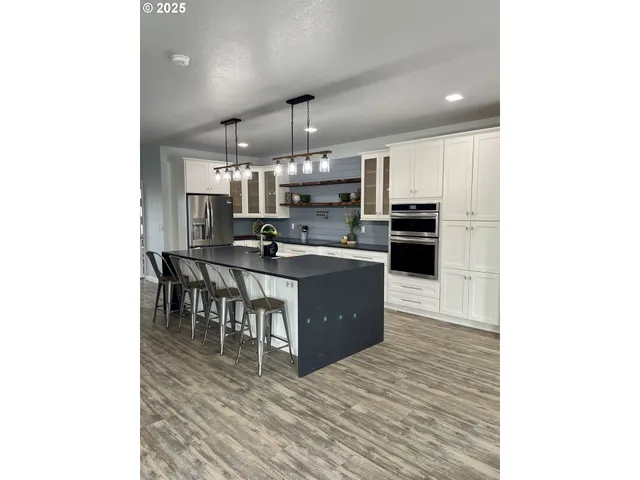 a kitchen with stainless steel appliances kitchen island granite countertop a stove and a refrigerator