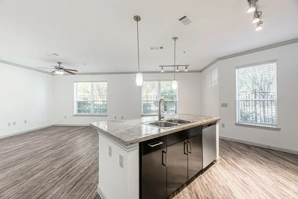 a kitchen with a sink a window and wooden floor