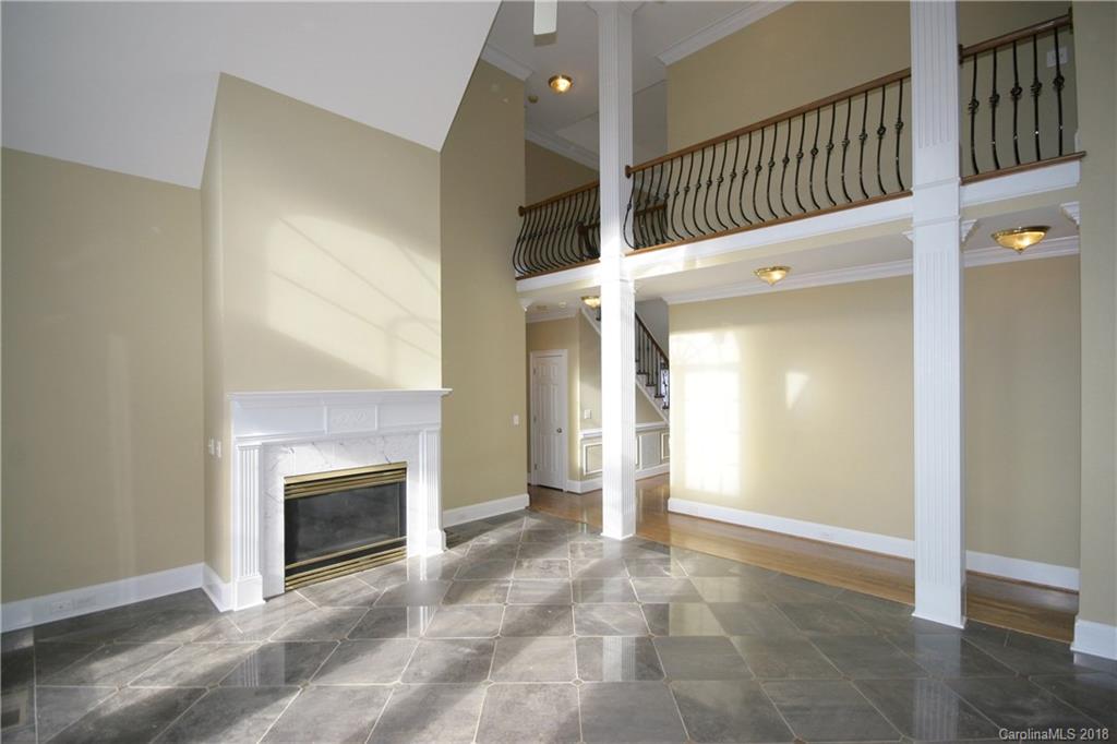 18628 Square Sail Road Cornelius, NC 28031 - Photo 5 of 19 a view of an empty room with a fireplace and a window