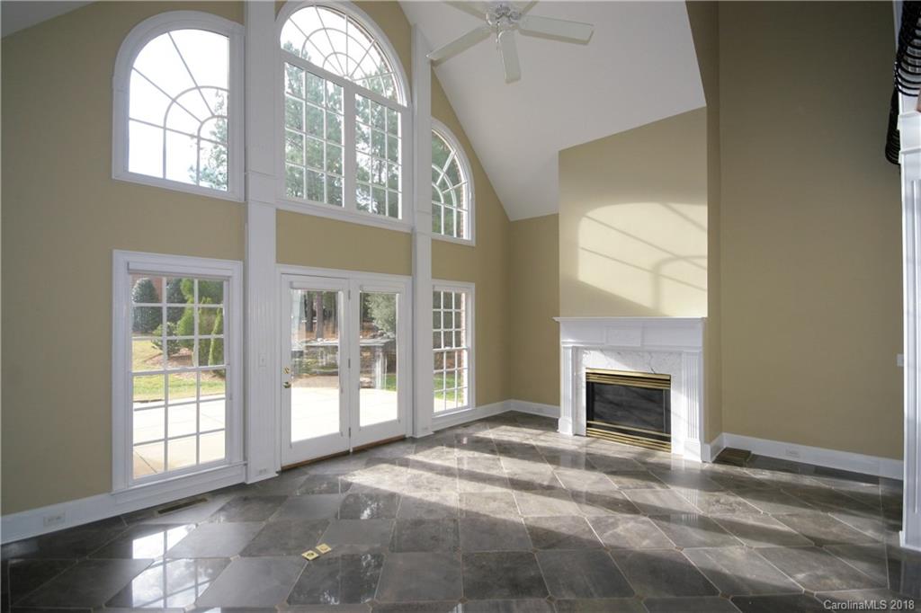 18628 Square Sail Road Cornelius, NC 28031 - Photo 6 of 19 an empty room with windows cabinet and fireplace