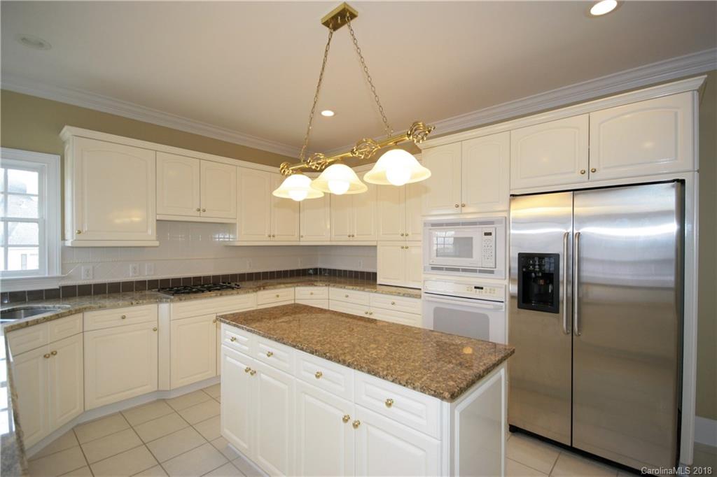 18628 Square Sail Road Cornelius, NC 28031 - Photo 8 of 19 a kitchen with white cabinets and stainless steel appliances