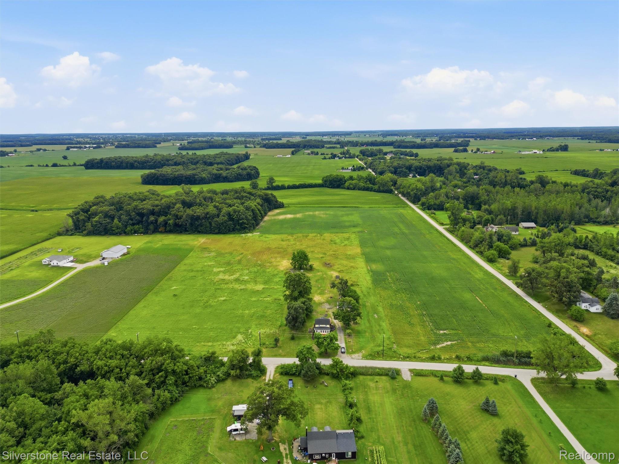 9691 Grames Road Maybee, MI 48159 - Photo 4 of 44 Agricultural landscape featuring cultivated fields, wooded areas, and scattered residential properties