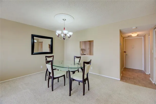 a view of a dining room with furniture and a chandelier