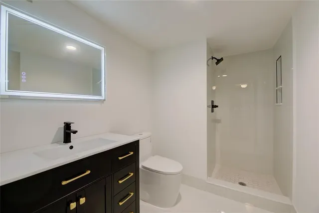 a bathroom with a sink a toilet a shower and a mirror