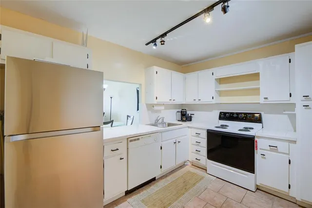 a kitchen with white cabinets and white appliances