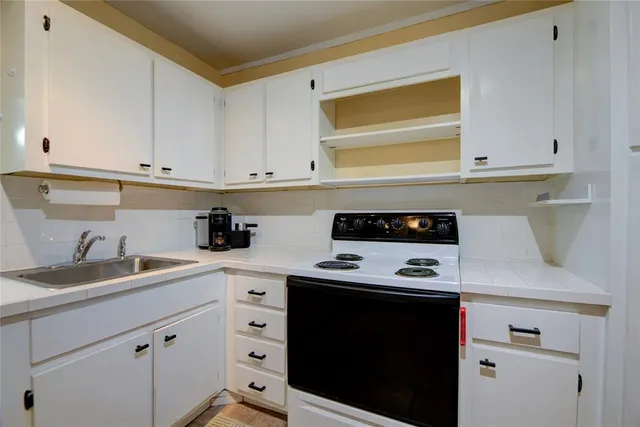 a kitchen with white cabinets and appliances