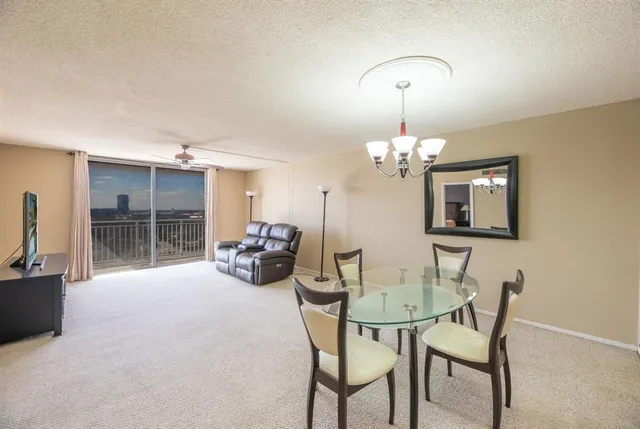 a view of a dining room with furniture and chandelier