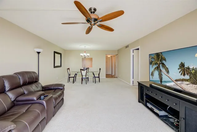 a living room with furniture and a ceiling fan