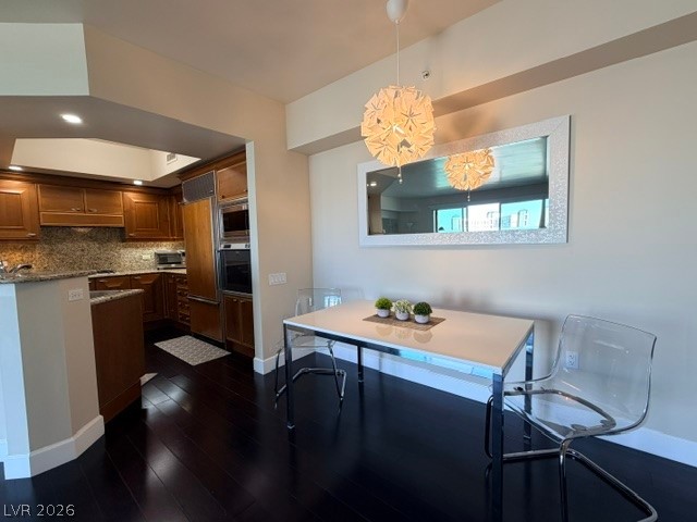 2777 Paradise Road, Unit 807 Las Vegas, NV 89109 - Photo 34 of 61 A well-lit kitchen with rich wood cabinetry flows into a contemporary dining space with sleek dark flooring.