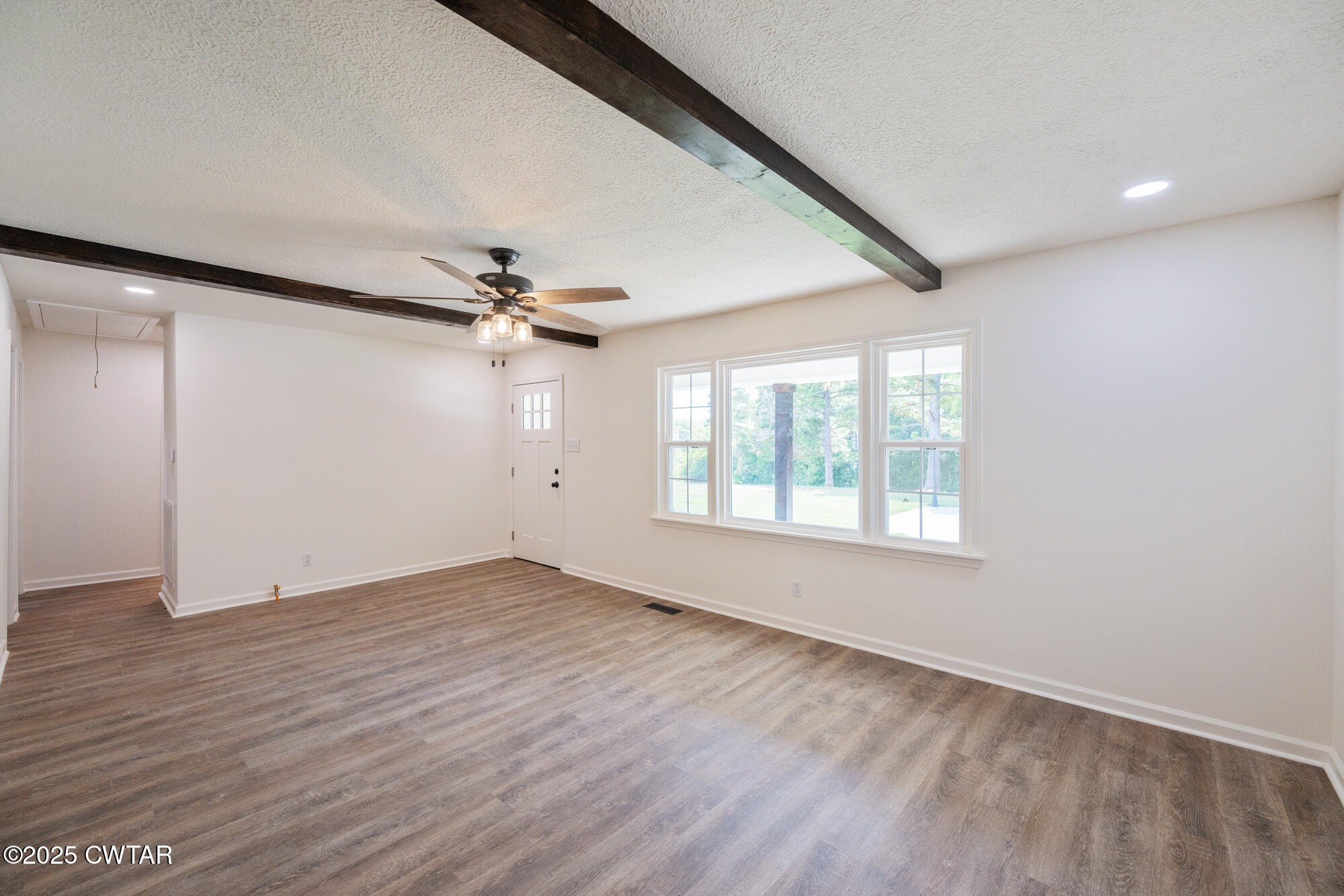 7371 Brooksie Thompson Road Bath Springs, TN 38311 - Photo 11 of 25 an empty room with wooden floor fan and windows