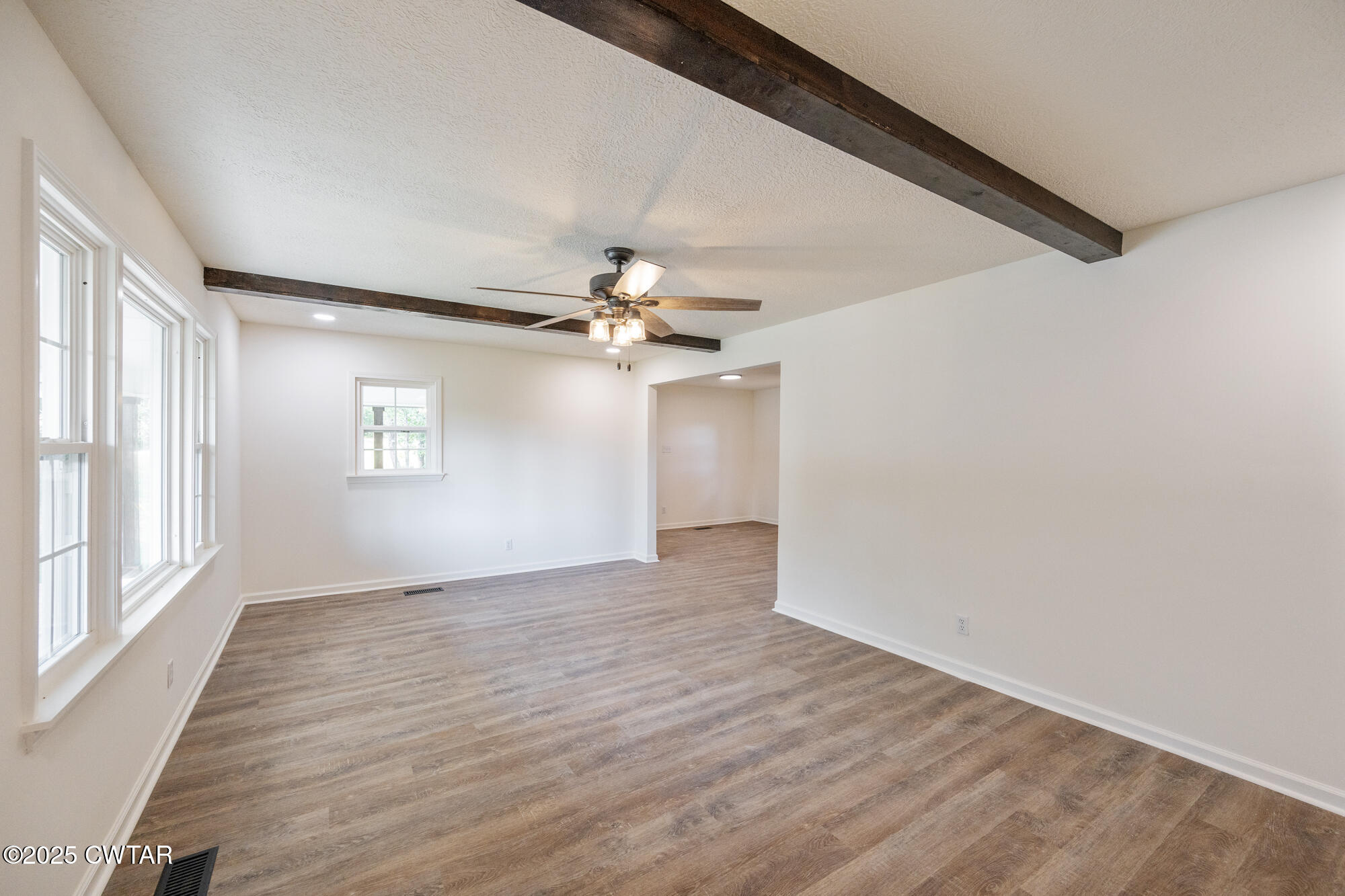 7371 Brooksie Thompson Road Bath Springs, TN 38311 - Photo 12 of 25 a view of an empty room with wooden floor and a window