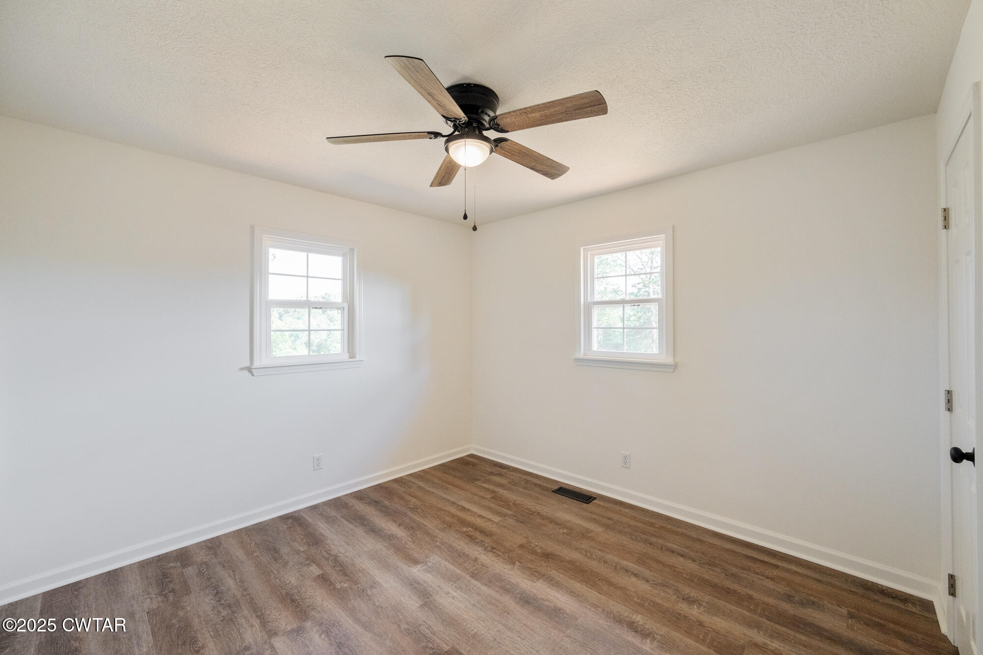 7371 Brooksie Thompson Road Bath Springs, TN 38311 - Photo 14 of 25 a view of empty room with wooden floor and fan