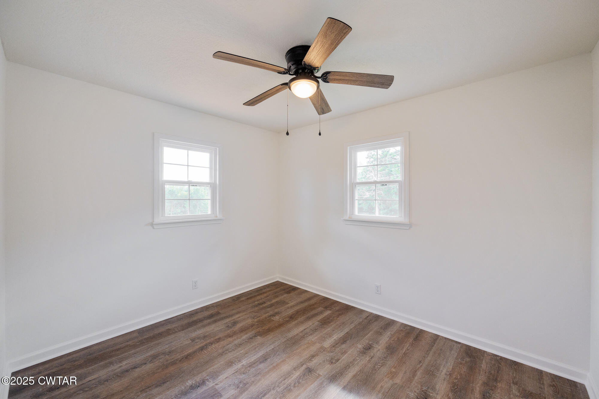 7371 Brooksie Thompson Road Bath Springs, TN 38311 - Photo 15 of 25 a view of empty room with wooden floor and ceiling fan