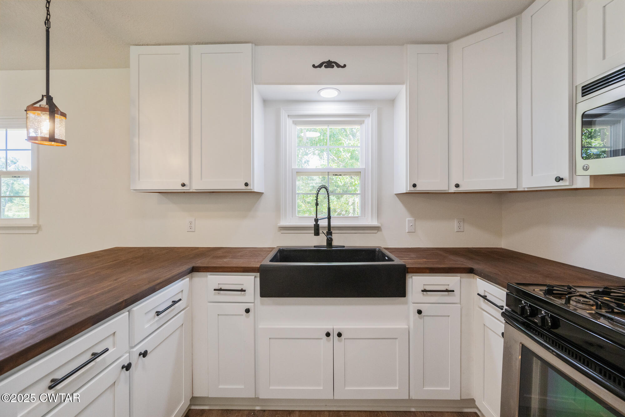 7371 Brooksie Thompson Road Bath Springs, TN 38311 - Photo 10 of 25 a kitchen with white cabinets and a stove top oven