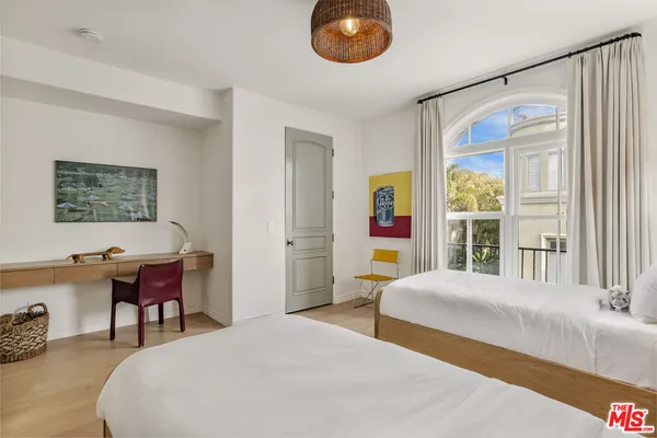 a spacious bedroom with a bed and a chandelier