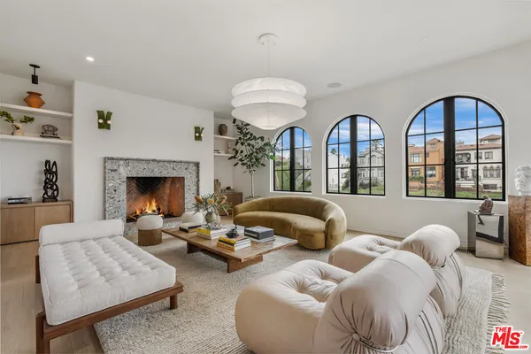 a living room with furniture a fireplace and a chandelier