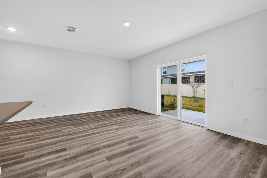 31264 Paper Birch Street Wesley Chapel, FL 33545 - Photo 12 of 32 a view of an empty room with wooden floor and windows