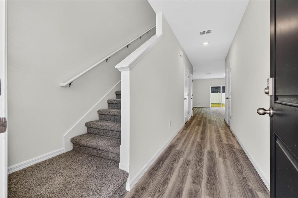31264 Paper Birch Street Wesley Chapel, FL 33545 - Photo 2 of 32 a view of a hallway with wooden floor and staircase