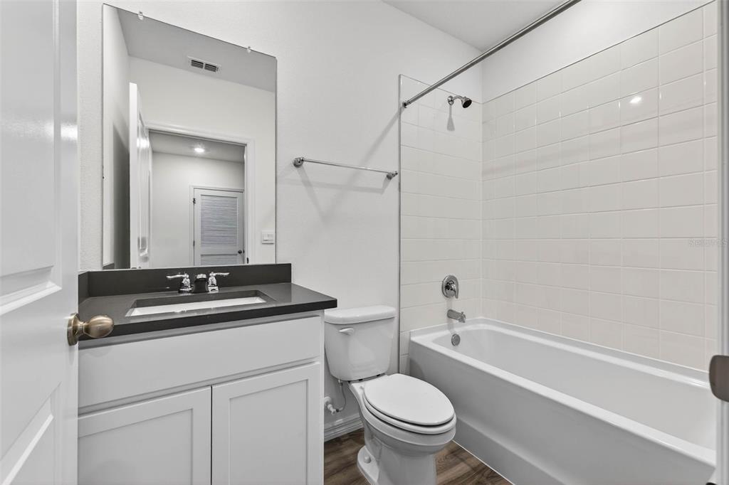 31264 Paper Birch Street Wesley Chapel, FL 33545 - Photo 23 of 32 a bath room with a sink a toilet and a mirror