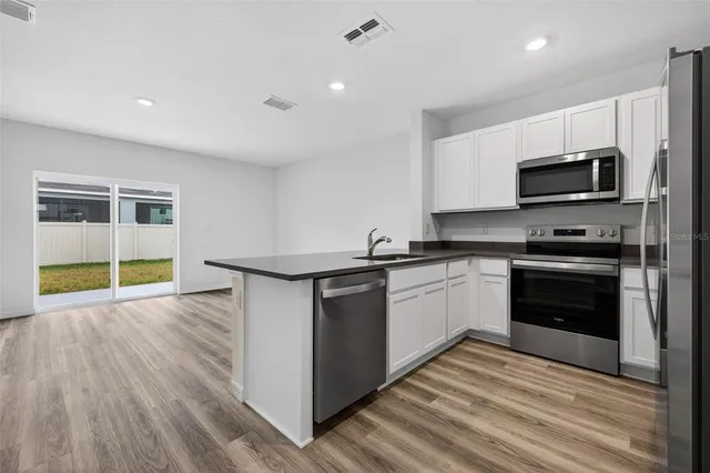 a kitchen with a sink and steel appliances