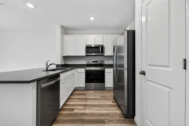 a kitchen with granite countertop a refrigerator and a stove