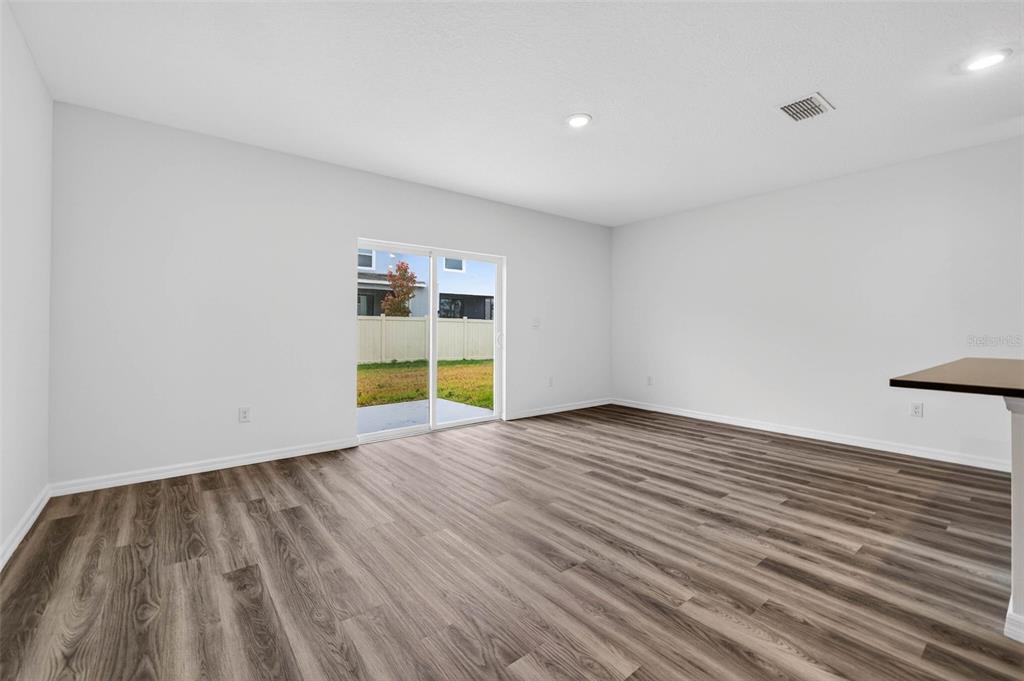 31264 Paper Birch Street Wesley Chapel, FL 33545 - Photo 10 of 32 a view of empty room with wooden floor and windows