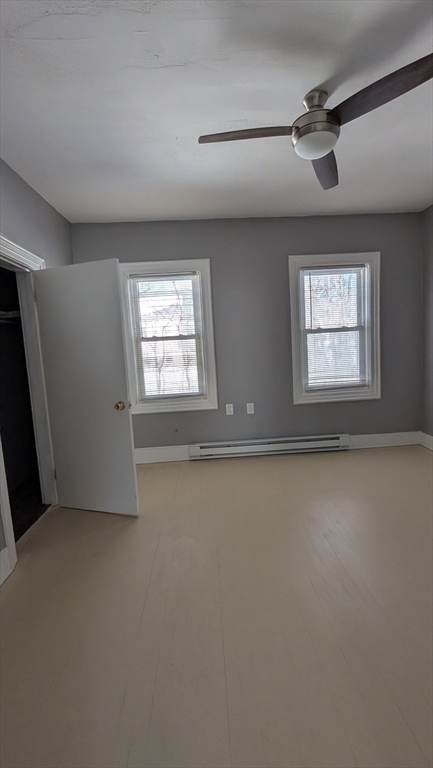 6 Brandon Road, Unit 2 Dudley, MA 01571 - Photo 4 of 9 an empty room with windows and fan