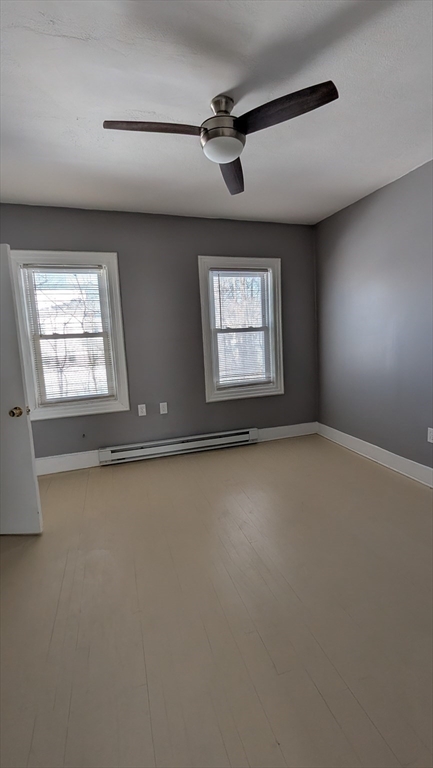 6 Brandon Road, Unit 2 Dudley, MA 01571 - Photo 5 of 9 an empty room with windows and ceiling fan
