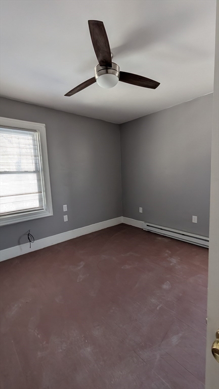 6 Brandon Road, Unit 2 Dudley, MA 01571 - Photo 6 of 9 an empty room with a ceiling fan and window