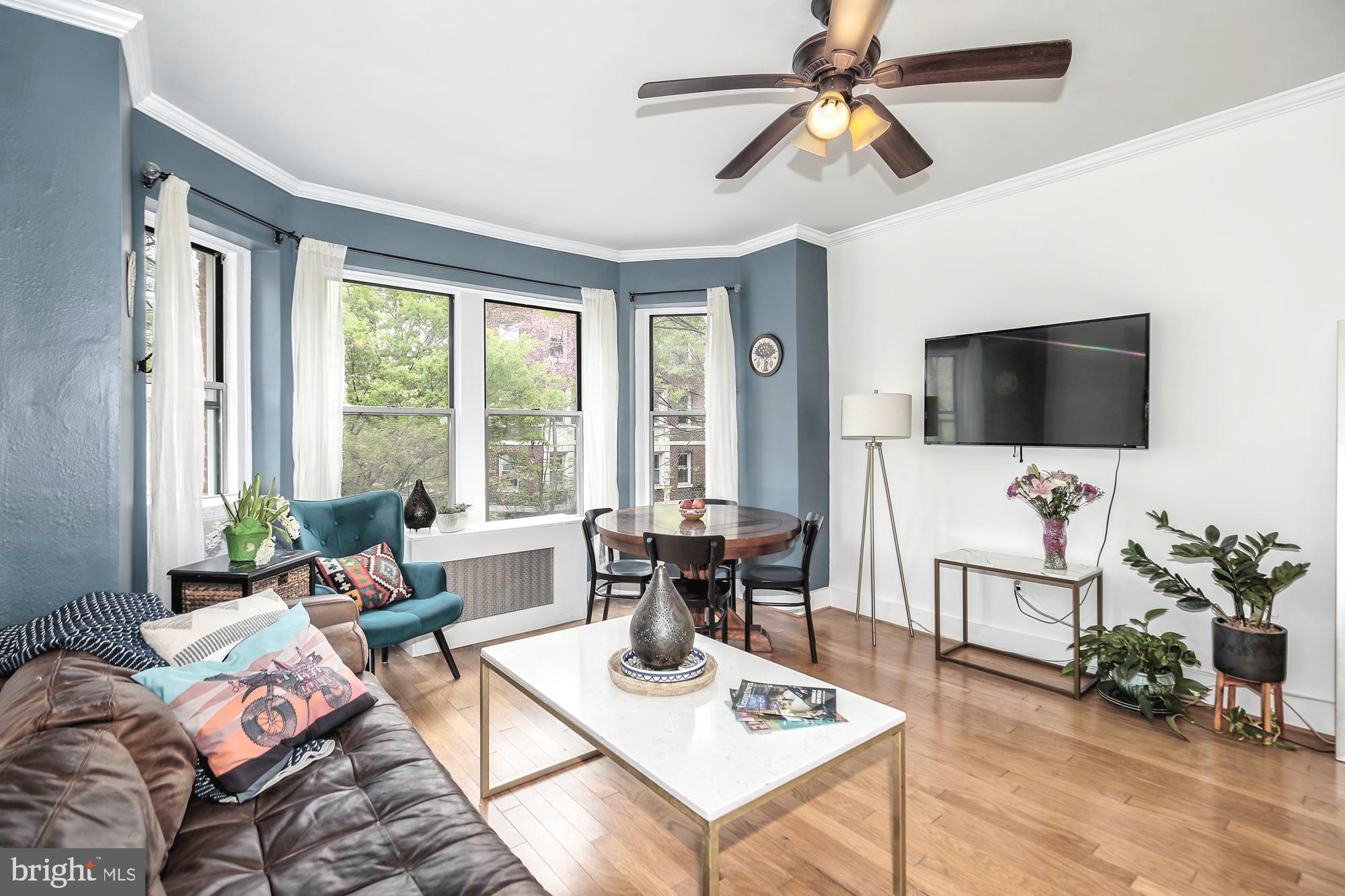 1820 Clydesdale Place Northwest, Unit 103 Washington, DC 20009 - Photo 6 of 14 a living room with furniture a flat screen tv and a large window