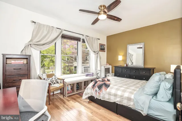 a bedroom with a bed couch and a large window