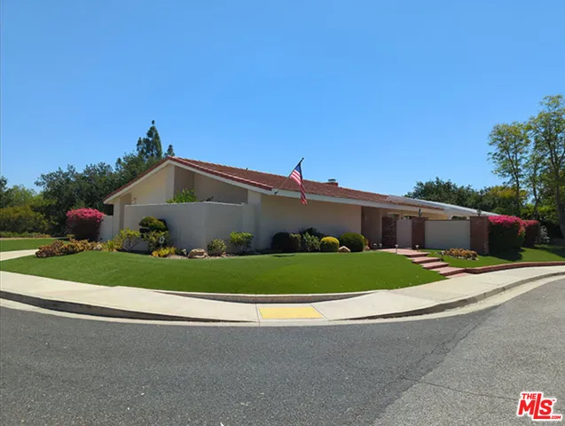 a front view of a house with garage and plants