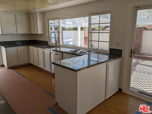 a kitchen with granite countertop a stove and white cabinets