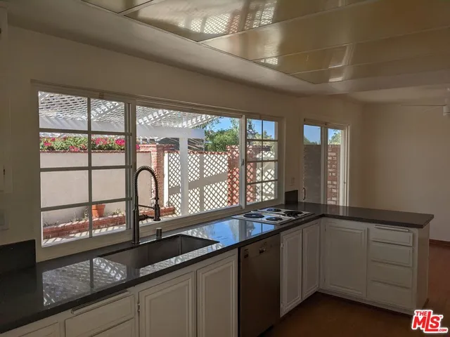 a kitchen with stainless steel appliances granite countertop a sink and a window
