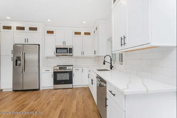 a kitchen with granite countertop a sink stove and refrigerator