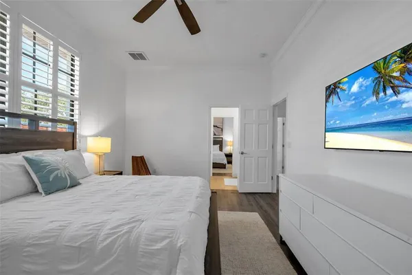 a bedroom with two beds and a ceiling fan