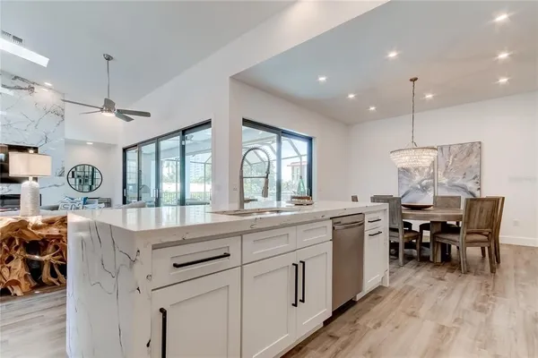 a kitchen with counter space dining table and wooden floor