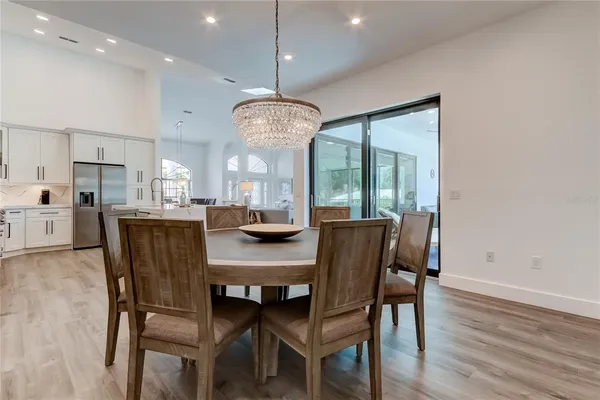 a dining room with furniture a chandelier and wooden floor