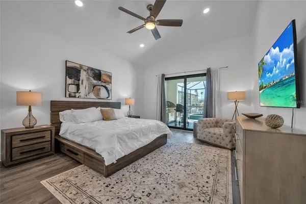 a bedroom with a bed painting on wall and a large window