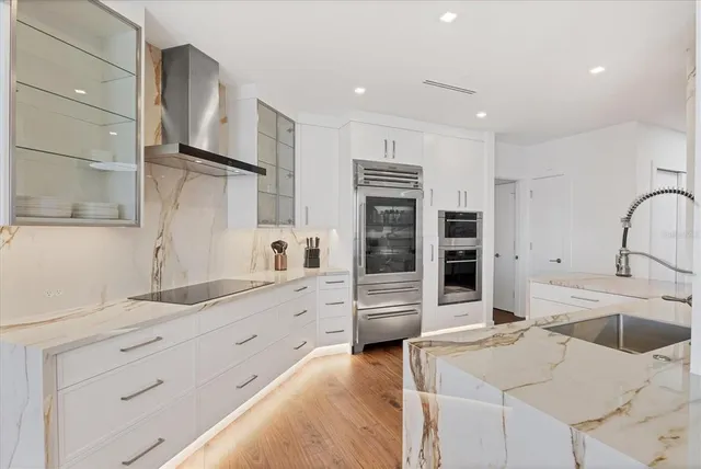 a kitchen with stainless steel appliances kitchen island granite countertop a sink and a refrigerator