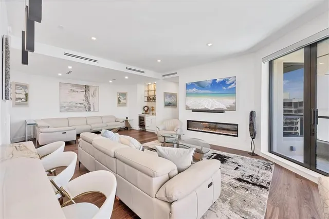 a living room with furniture a rug and kitchen view