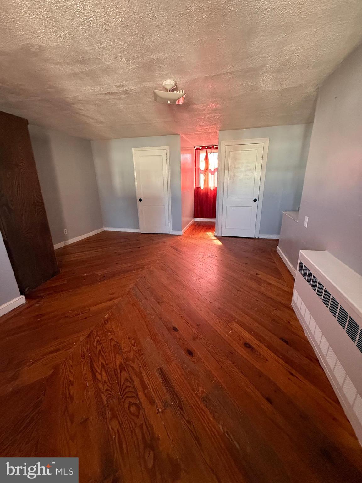 557 Wiltshire Road Upper Darby, PA 19082 - Photo 22 of 27 a view of an empty room with window and wooden floor