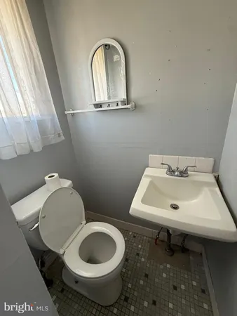 a bathroom with a toilet sink and mirror