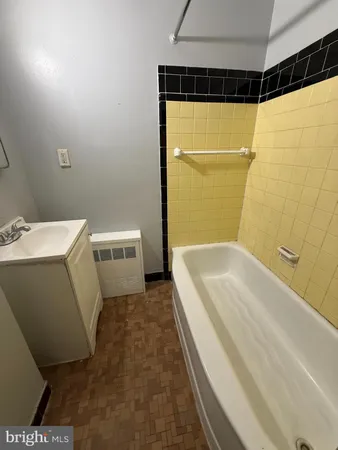 a bathroom with a tub a sink and a shower