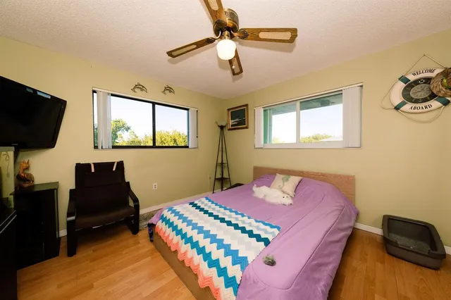 a bedroom with a bed and a flat tv screen on dresser